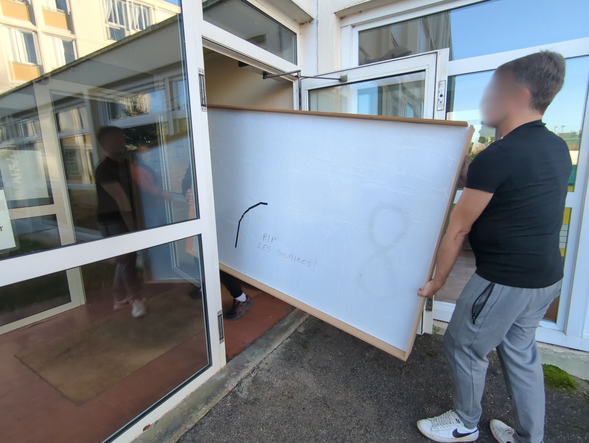 Moving a table, passing through the door of the CCAS residence. It says "RIP Les Douaires"